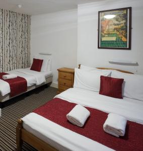 伦敦圣亚詹斯酒店的酒店客房带两张红色和白色的床单