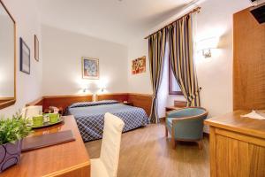 罗马吉伊迪弗尔坎诺酒店的配有一张床和一张书桌的酒店客房