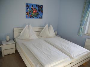 青斯特Sünnenkringel 68 Appartement 1的白色的床、白色床单和枕头