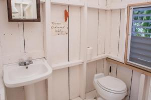 珀拉什奇亚Ranguana Caye Cabanas的白色的浴室设有卫生间和水槽。