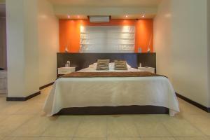 比亚米尔港Hotel La Laguna Galapagos的一间卧室配有一张带橙色墙壁的大床