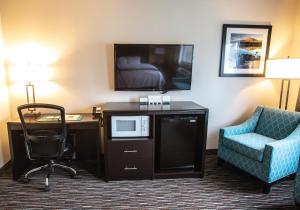科蒂奇格罗夫Cottage Grove Inn的酒店客房配有书桌、电视和椅子。