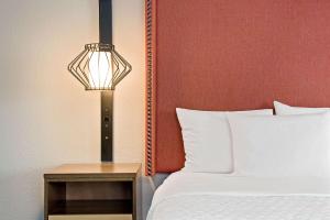南旧金山旧金山机场北拉金塔套房酒店的一间卧室配有一张床和一张桌子旁的灯