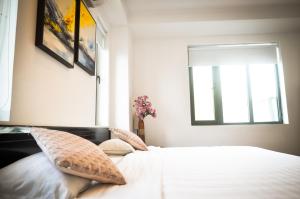 罗夷Thanh Binh Hotel的卧室配有带枕头的床铺和窗户。