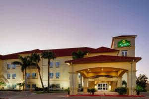 RaymondvilleLa Quinta Inn Suites by Wyndham Raymondville Harlingen的前面有标志的酒店