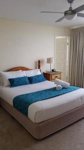黄金海岸贝卡昂勒酒店的一间卧室配有一张带蓝色毯子的大床