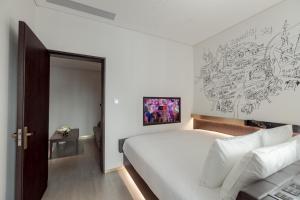 上海上海国际旅游度假区CitiGO欢阁酒店的卧室配有一张大床,墙上挂有绘画作品