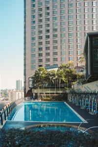 吉隆坡吉隆坡嘉登斯圣吉尔斯签名酒店及公寓的一座高楼前的大型游泳池