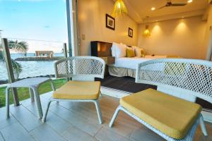 阿皮亚托米西纳岛度假酒店的带床和椅子的房间以及一间卧室