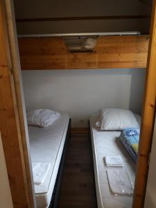 圣雷热雷梅累兹Chalet calme的配有白色床单的客房内的两张双层床