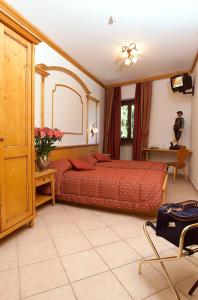 塔尔维西奥Hotel Valle Verde - Rent Ski & Bike的一间卧室配有一张带红色棉被的大床