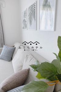 廿日市OUCHI HOTEL Miyajimaguchi的一张带枕头的沙发以及墙上的照片