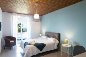 伊斯基亚Paradise Relais Villa Janto'的一间卧室设有一张床和一个大窗户
