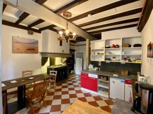 圣让皮耶德波尔Gite de la Porte Saint Jacques: a hostel for pilgrims的一间设有红色橱柜和 ⁇ 格地板的大厨房