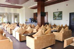 槟知越南Uc酒店的一间设有棕色椅子和桌子的等候室