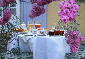 莫扎克和格朗德-卡斯唐Domaine de la Chartreuse Dautré的一张带食物和饮料的白色桌子,鲜花