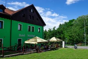JiříkovWaldhof的外边有遮阳伞的绿色建筑