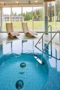 萨拉Holiday Club Salla Apartments的两把椅子坐在大楼的游泳池里