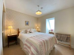 爱丁堡St Margaret's Cottage, Edinburgh的一间卧室配有一张带粉色和白色毯子的床