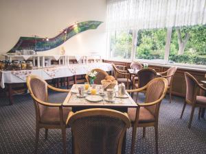 莱茵河畔的宾根Rheinhotel Starkenburger Hof的用餐室设有桌椅和窗户。
