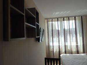 斯图托沃Apartament Królewiecki - pokoje gościnne的一间卧室设有窗户、窗帘和婴儿床