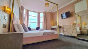布莱克浦蒂凡尼酒店的一间卧室配有一张大床和镜子