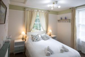 RydalRydal Lodge的卧室配有白色的床和2条毛巾