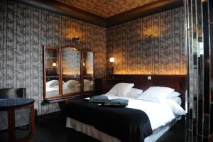 布鲁塞尔Le Berger Hotel的一间卧室配有一张大床和镜子