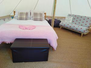 阿贝尔格莱Yr Wyddfa Bell Tent - Pen Cefn Farm, Abergele, Conwy的一间卧室配有一张床,一张沙发位于帐篷内
