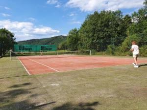 ÜbereisenbachSabine’s Gästehaus的两人在网球场打网球
