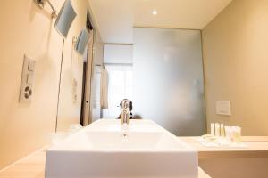 洛桑旅客精品酒店的浴室设有白色水槽和镜子
