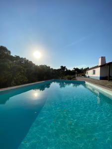 阿维斯Monte das Pedras - Avis的一个大型蓝色游泳池,背面是阳光