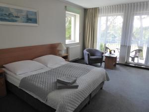 加茨比亚格拉Willa Dalba的一间卧室配有一张床、一把椅子和窗户。
