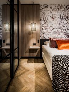 马斯特里赫特马斯特里赫特凡德瓦克酒店的一间卧室设有床和两张桌子,还有一面墙
