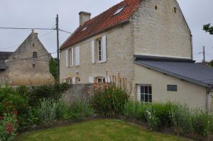 Longues-sur-MerLe petit clos du Bessin的一座老砖砌的建筑,在院子里有塔