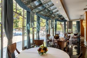 雅典绿洲公寓式酒店的餐厅设有桌椅和大窗户。
