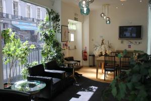 伦敦Elysee Hyde Park的客厅配有沙发和植物桌子
