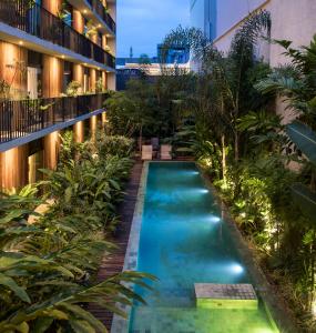 马瑙斯亚马逊别墅酒店的植物繁茂的建筑中间的游泳池