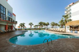 默特尔比奇Grande Cayman Resort的一座带椅子和棕榈树的度假村游泳池