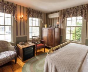 普罗温斯敦斯拿歌木屋酒店的一间卧室设有一张床、一台电视和窗户。