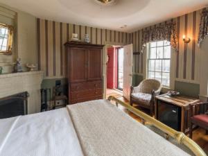 普罗温斯敦斯拿歌木屋酒店的一间卧室设有一张床,客厅设有壁炉。