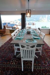 莫斯克内斯Lofoten panoramic luxury home with sauna的餐桌、白色椅子和大窗户