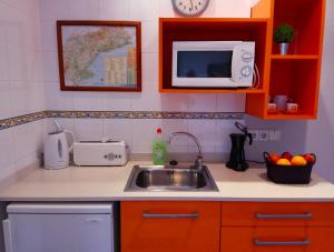 代尔特布雷卡萨布兰卡佩蒂特酒店的厨房配有水槽和微波炉