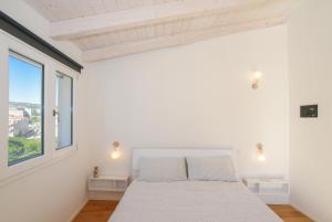 奥列纳Tatta & Nanna Rooms的白色的卧室设有床和窗户
