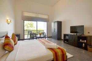 卡特勒格默Grand Tamarind Lake的一间卧室配有一张大床和一台平面电视