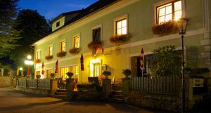 YspertalGasthof-Hotel zur Linde的前面有旗帜和鲜花的建筑