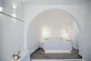 迈洛波塔斯Manthos Place 2的一间位于拱门上的白色卧室,配有一张床铺