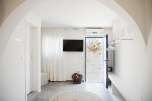 迈洛波塔斯Manthos Place 2的一条带白色墙壁的走廊和一扇带电视的门