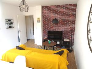 里尔Appartement Lille/1ch/stationnement gratuit的客厅设有黄色沙发和砖墙