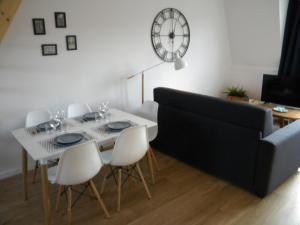 里尔Apartment Lille - Proche métro - Stationnement gratuit的一间带桌椅和时钟的用餐室